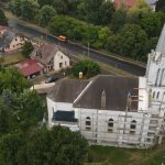Scenic aerial shot of a church in Tiszavasvári, Hungary, surrounded by lush greenery and town buildings.