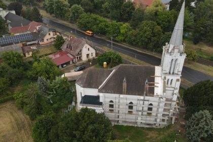Scenic aerial shot of a church in Tiszavasvári, Hungary, surrounded by lush greenery and town buildings.